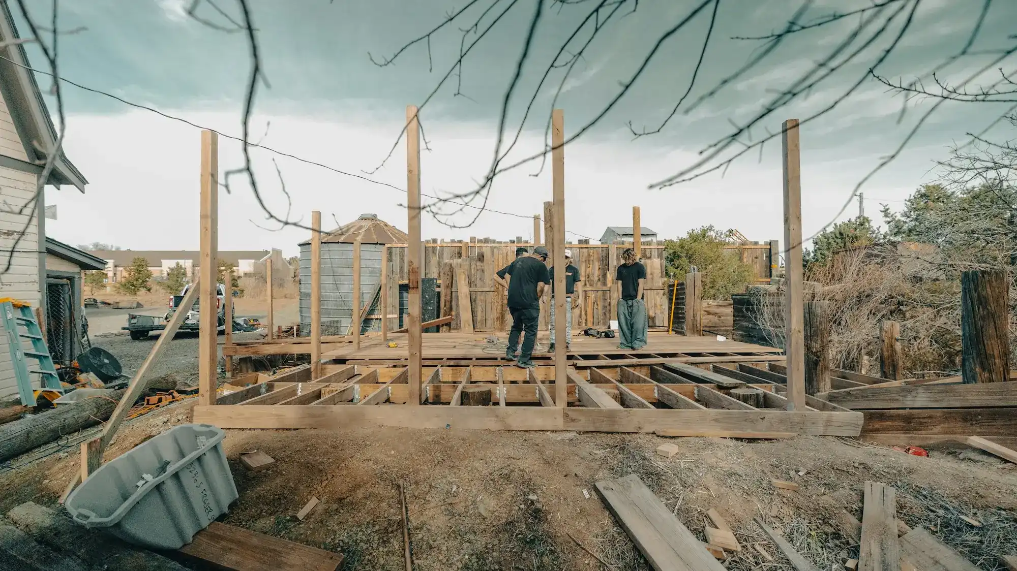 A crew building a wood-framed structure outdoors (stock photo)