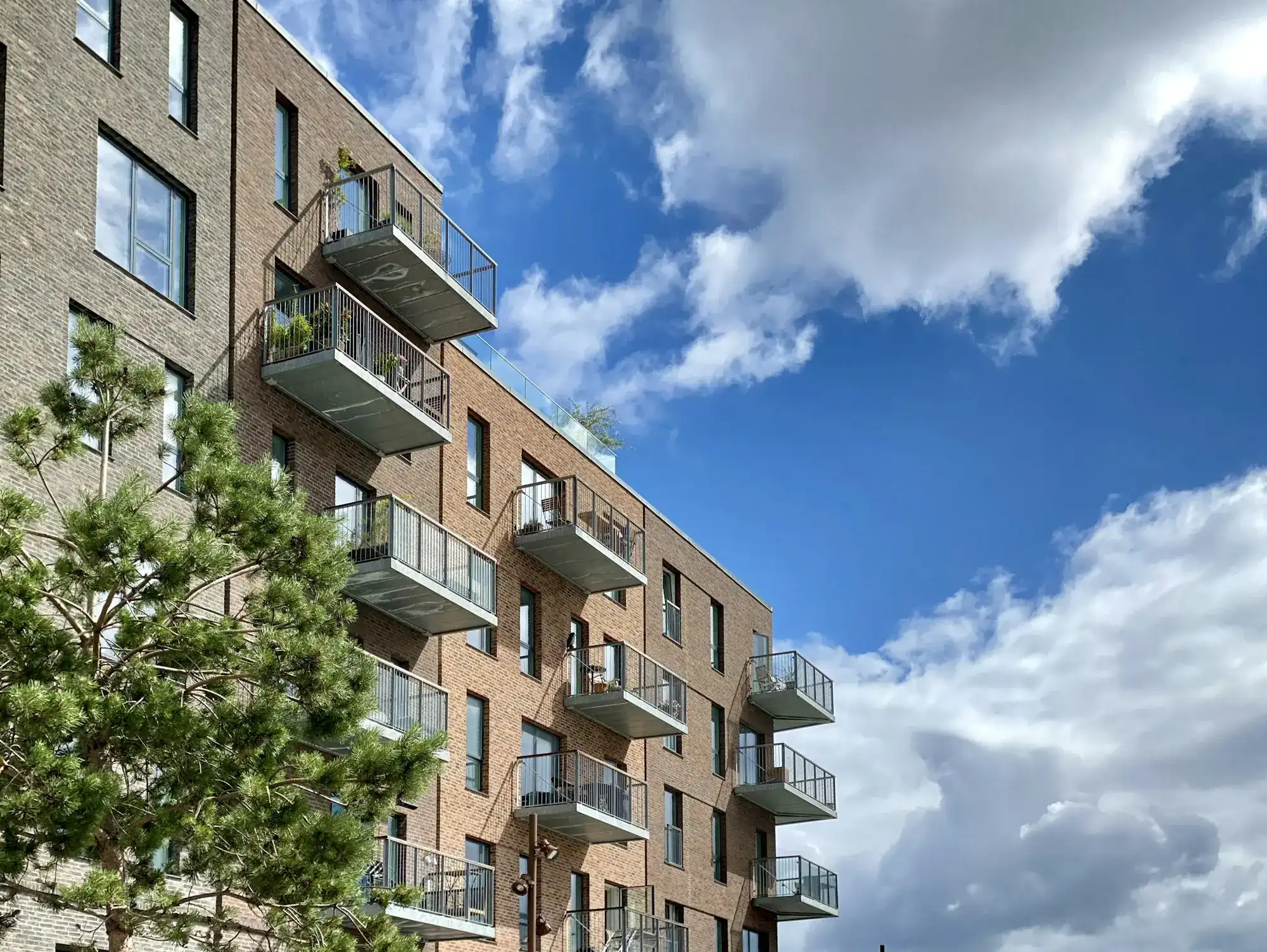 A brick apartment building with balconies (stock photo)