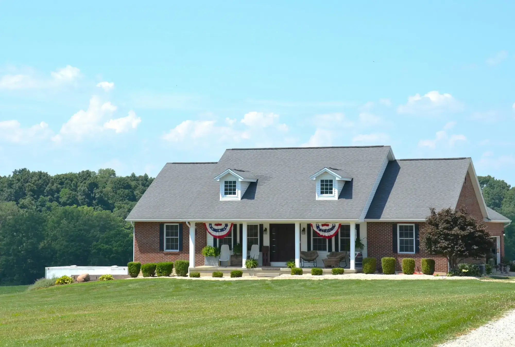 A Cape Cod style house with dormers and a front porch (stock photo)