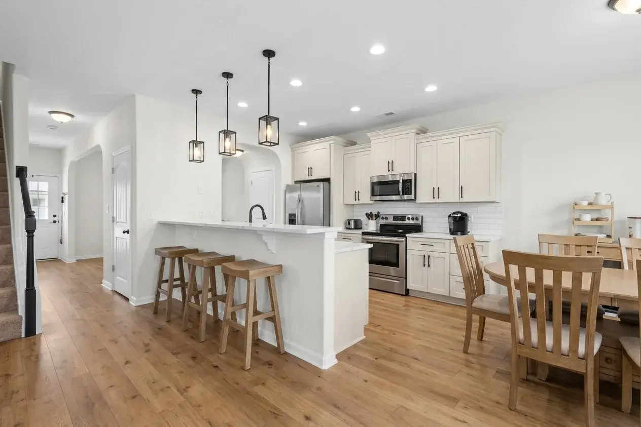 The same kitchen as an AI picture with white shaker cabinets, black pendants and oak floors, Modern Farmhouse with Better finishes (AI rendering, for illustration)