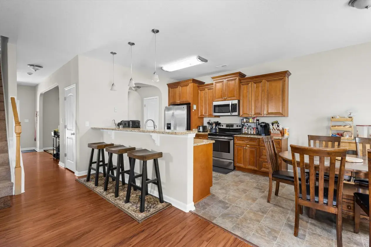 A kitchen with honey oak cabinets, granite counters and tile floor, before the work