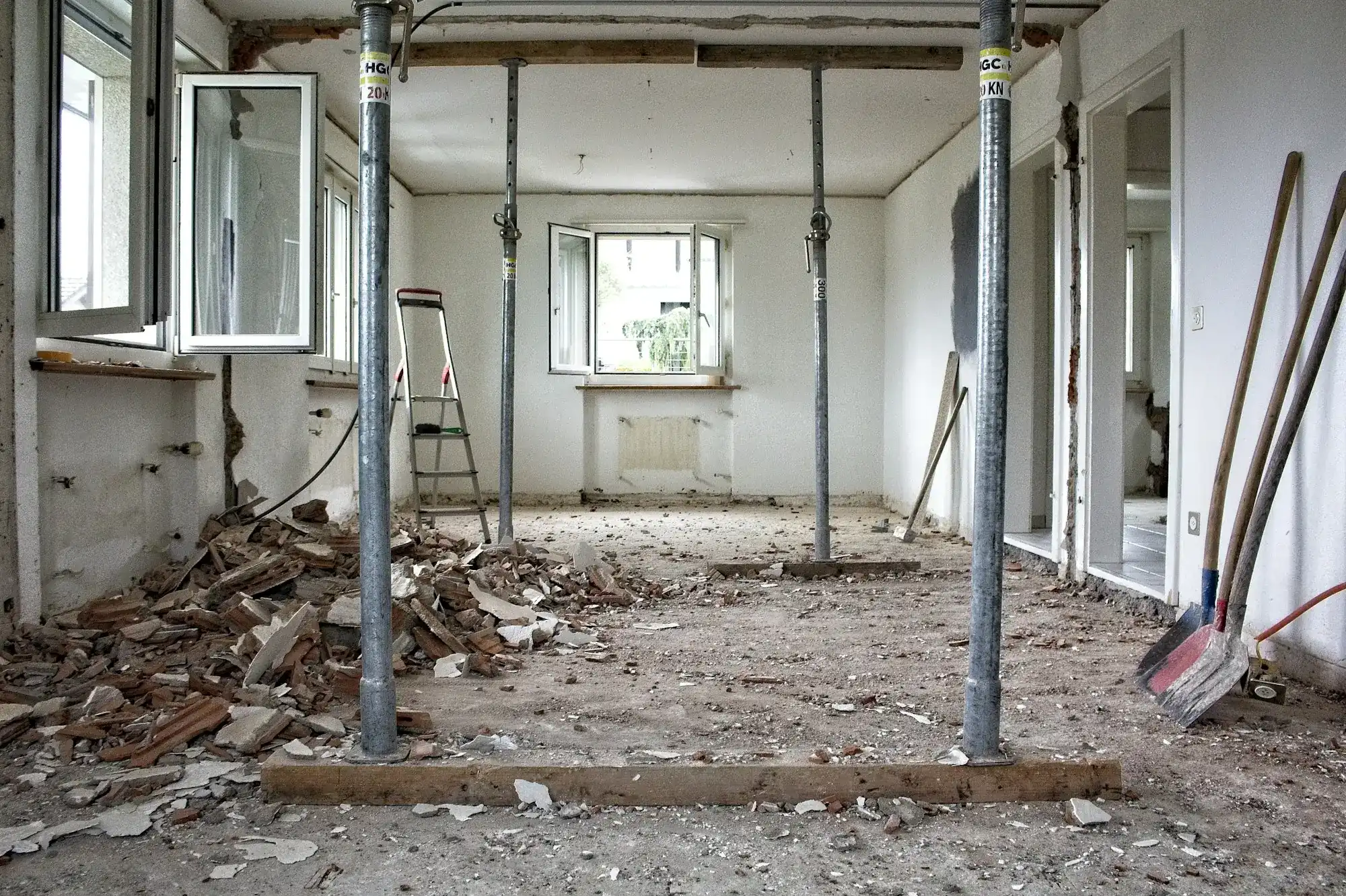 A gutted room under renovation with support posts and debris (stock photo)