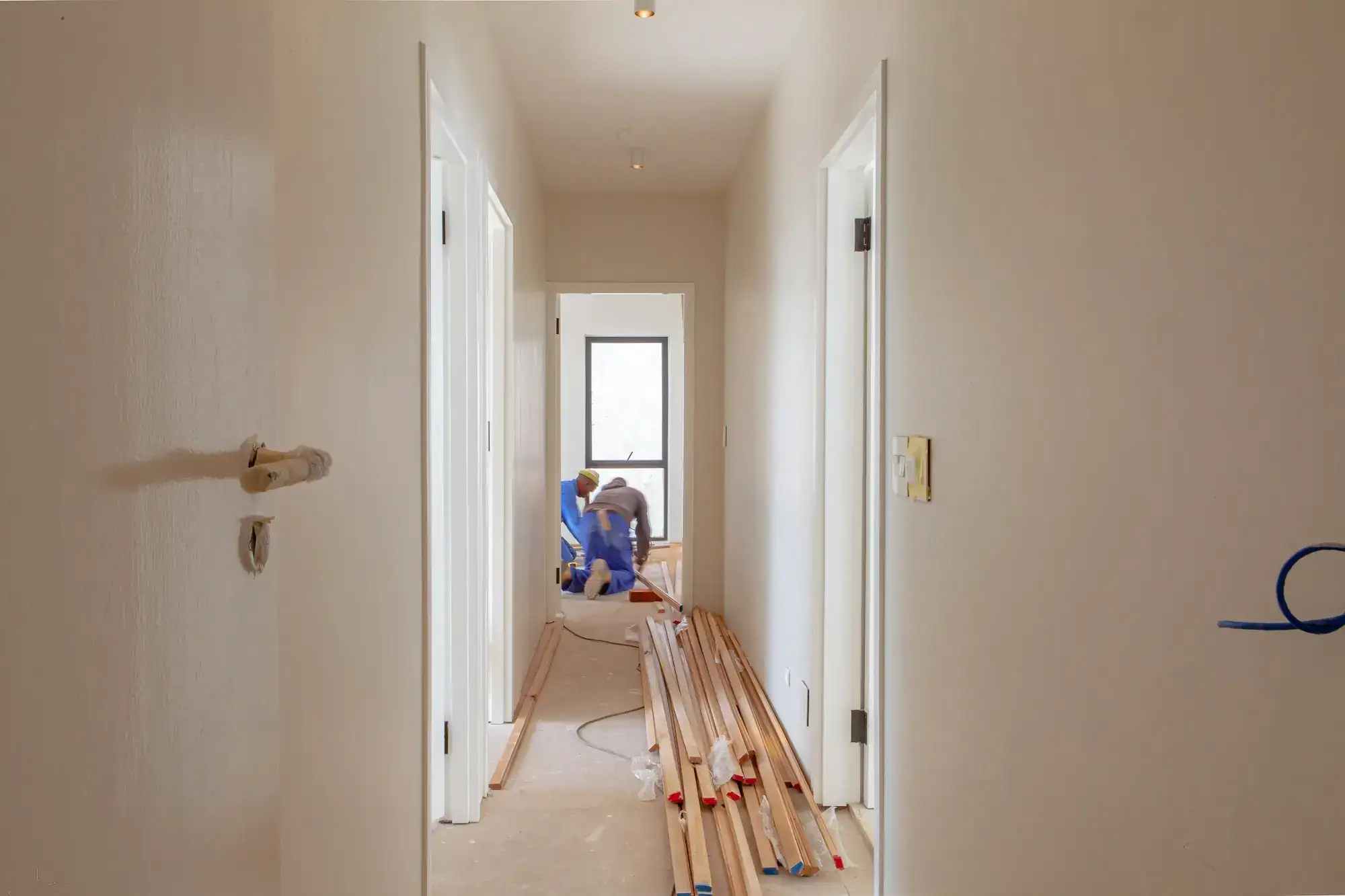 A worker on the floor of a hallway being finished (stock photo)